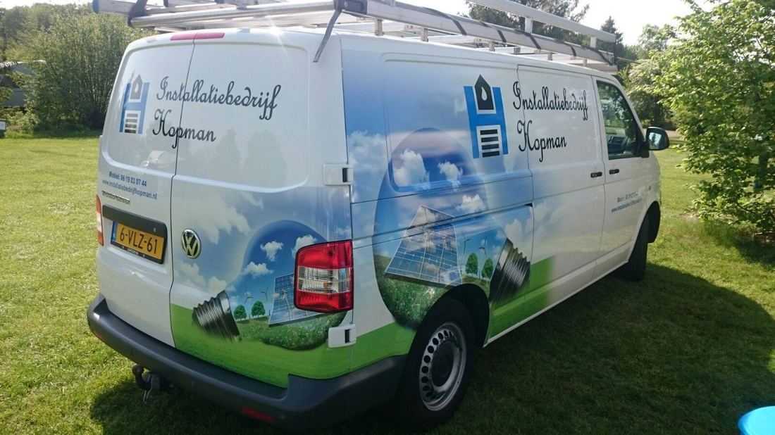 De bedrijfsbus van Installatiebedrijf Hopman van achteren gezien, met bedrijfslogo op de deuren